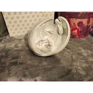 porcelain nativity scene figurine featuring an angel wrapping its wings around t